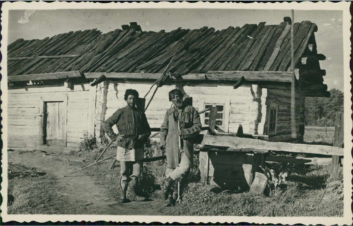 Polesie, dwaj wieśniacy przed drewnianą chatą